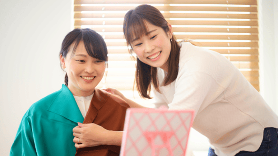 [alt=カラードレープを使用してパーソナルカラー診断を行っている様子。]