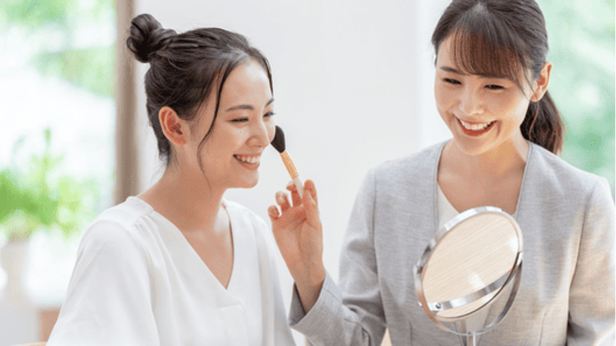 美容部員がお客様にメイクを施している様子