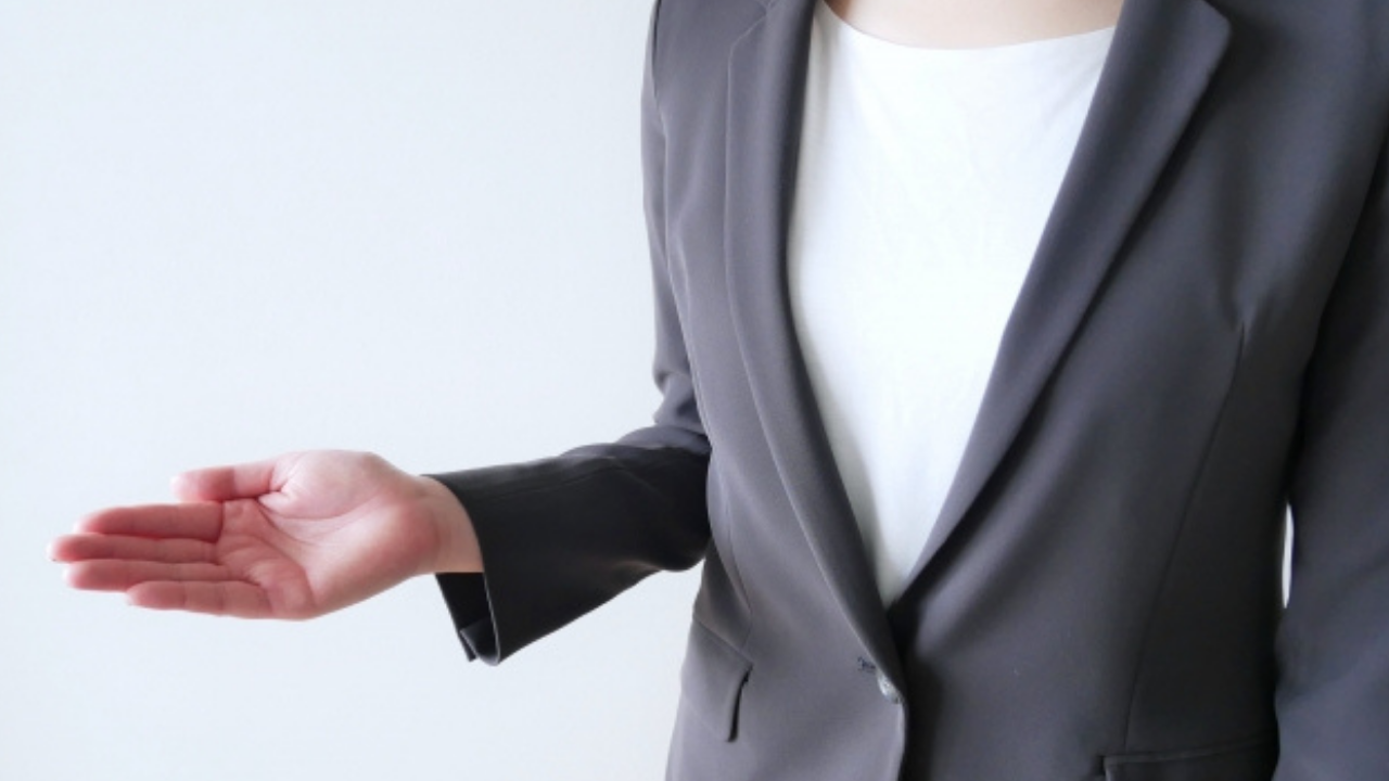 ウェディングプランナーが案内のジェスチャーをしている様子。