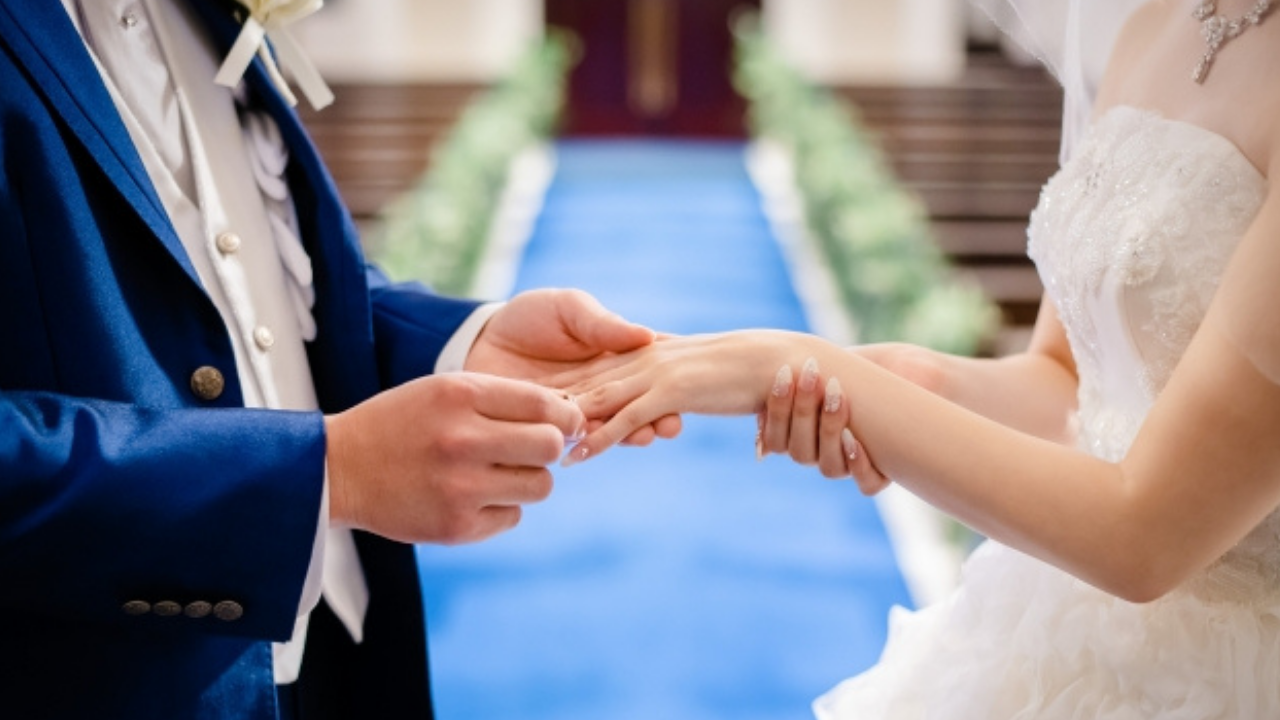 新郎新婦がチャペルで指輪交換をしている様子。