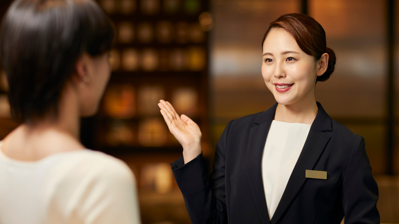 笑顔でご案内するウェディングプランナーの姿。